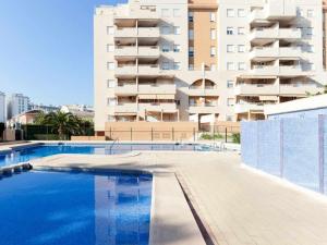 una piscina vacía frente a un edificio en Apartamento jardines playa gandia, en Puerto de Gandía