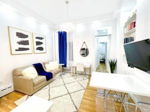 62-2B Renovated 1BR in Prime Upper East Side في نيويورك: غرفة معيشة مع أريكة وتلفزيون