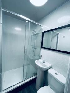 La salle de bains est pourvue d'une douche, de toilettes et d'un lavabo. dans l'établissement Star Apartments, à Manchester