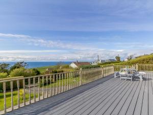 a wooden deck with a table and a bench on it at 4 Bed in Tintagel 75335 in Forrabury
