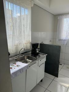 a small kitchen with a sink and a window at Apartamento em Várzea Grande MT in Várzea Grande