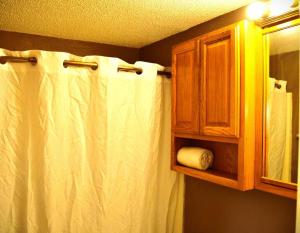 een badkamer met een wit douchegordijn en een kast bij Red 3 in Grand Forks