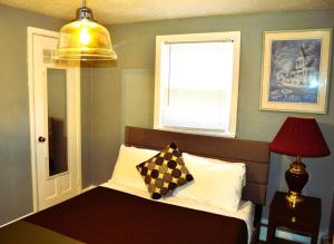 een slaapkamer met een bed, een lamp en een raam bij Red 3 in Grand Forks