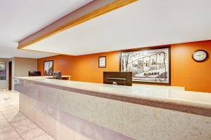 a lobby with a bar with a clock on the wall at Super 8 by Wyndham Albany in Albany +20 photos