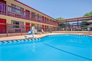 a large swimming pool in front of a building at Super 8 by Wyndham Albany in Albany