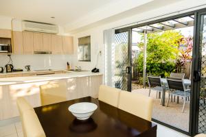 cocina y comedor con mesa y sillas en Gladstone Heights Executive Apartments, en Gladstone