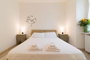 a bedroom with a white bed with towels on it at Splendido Appartamento con 2 camere da letto in Milan