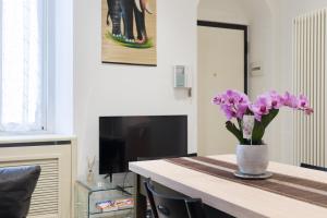a vase of purple flowers sitting on a table at Splendido Appartamento con 2 camere da letto in Milan