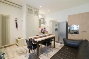 a kitchen and dining room with a table and a couch at Splendido Appartamento con 2 camere da letto in Milan +12 photos