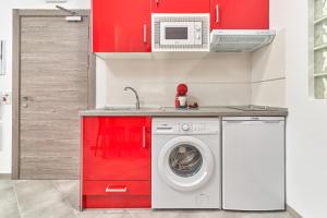 een keuken met rode kasten en een wasmachine bij Nerja Boutique B2 Street level in Nerja