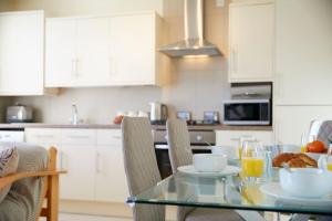 a kitchen with a glass table with a bowl of food at Ashore@Jubilee in Filey