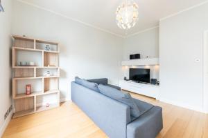 a living room with a blue couch and a television at Speacial Offer! Bright & Central Apt - Up to 4 in London