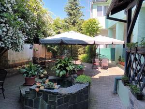 eine Terrasse mit einem Sonnenschirm und einem Brunnen mit Pflanzen in der Unterkunft Hotel P7 in Lučenec