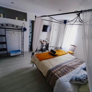 1 dormitorio con 1 cama con dosel en La Douce Parenthèse - 3 chambres d'hôtes-Accueil motards en Montirat