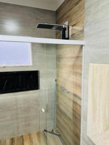 a bathroom with a shower with a glass door at Linda casa em condomínio in Tatuí