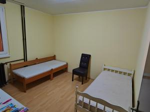 ein Zimmer mit 2 Betten und einem Stuhl darin in der Unterkunft Stan na dan in Zrenjanin