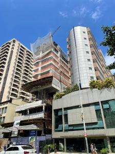 Dos edificios altos están en construcción en una calle de la ciudad. en Flat in Apoador 2, en Río de Janeiro