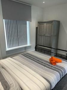 um quarto com uma cama com um objecto laranja em Town Centre Studio Flat em Merthyr Tydfil