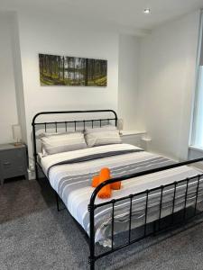 ein Schlafzimmer mit einem Bett mit einem orangefarbenen ausgestopften Tier darauf in der Unterkunft Town Centre Studio Flat in Merthyr Tydfil