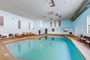 a large swimming pool in a room with chairs at North Conway Condo with Pool Access 2 Mi to Skiing in North Conway