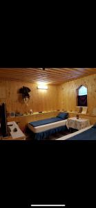 バタクにあるЕКО СПА вила ОРЛОВЕЦЪの木製の壁にベッド2台が備わるベッドルーム1室