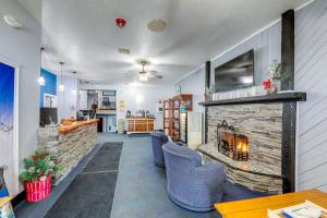 a living room with a fireplace and blue chairs at North Conway Condo with Pool Access 2 Mi to Skiing in North Conway
