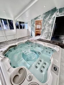 a hot tub in the middle of a room with windows at Hotel Le Provence - Restaurant Le Styx in La Palud-sur-Verdon