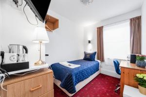 um pequeno quarto com uma cama e uma janela em Jubilee Hotel Victoria em Londres