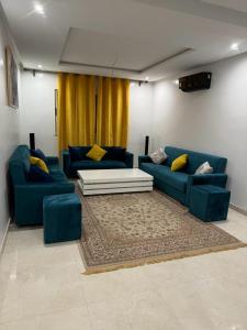 Coralia Bel F3 clim wifi Iptv في وجدة: غرفة معيشة مع أرائك زرقاء ووسائد صفراء