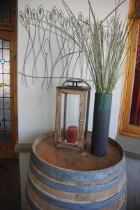 a lantern sitting on top of a barrel with a vase at Charming 3 bedroom house -No Loadshedding in Pretoria