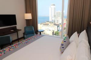 a hotel room with a large bed with a large window at Sofia Colombo City Hotel in Colombo