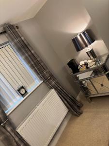 a room with a radiator and a window with a blind at Luxury Farm Country Retreat in Chippenham