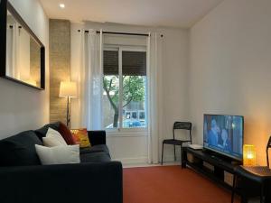 uma sala de estar com um sofá e uma televisão em Donosti House Hiru con Parking ESS03051 em San Sebastián