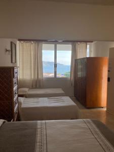 a hotel room with two beds and a large window at Villa Covadonga in Acapulco