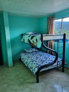 1 Schlafzimmer mit 2 Etagenbetten in einem Zimmer mit Fenster in der Unterkunft Hospedaje San Alberto 202-Ráquira in Ráquira