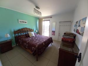 ein Schlafzimmer mit einem Bett und einem Stuhl darin in der Unterkunft Casa de descanso Olmue in Olmué
