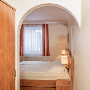a bedroom with a bed and a window at Hotel Daub in Bremervörde