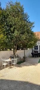 a table and chairs sitting under a tree at Gîte et Spa 21 in Savigny-le-Sec