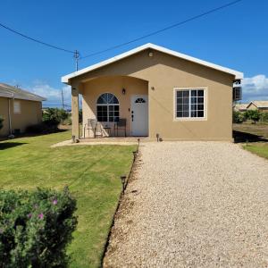 a house with a gravel driveway in front of it at Gated Cozy Urban Luxe Retreat in Portmore