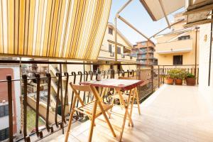 a balcony with a table and chairs on it at Casa Lu by Rental in Rome in Ladispoli