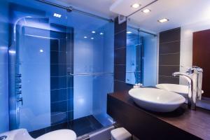 a bathroom with two sinks and a glass shower at Hotel Torre del Bosque Pasto in Pasto