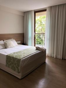 a bedroom with a large bed and a window at Cond Vista Azul in Pedra Azul