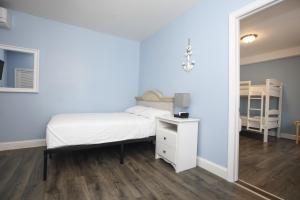Schlafzimmer mit einem weißen Bett und einem Spiegel in der Unterkunft Garfield Beach House in Wildwood
