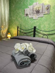 een slaapkamer met een bed met handdoeken en bloemen bij B&B Bovianum in Boiano