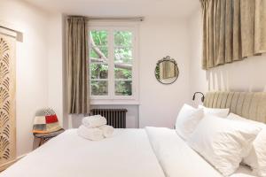 ein Schlafzimmer mit einem weißen Bett und einem Fenster in der Unterkunft Couple-in magical suite with jacuzzi in Thessaloniki