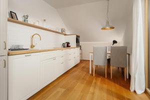 a kitchen with white cabinets and a table with two chairs at Haus Grundlsee in Grundlsee