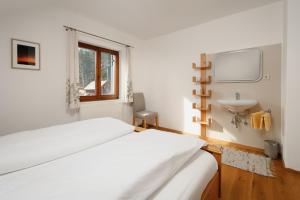 a white bedroom with a bed and a sink at Haus Grundlsee in Grundlsee