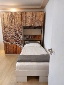 a bed in a room with a wooden wall at Ferienwohnung bis 4 Personen in Hannover in Hannover
