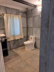 a bathroom with a toilet and a shower curtain at Zephyr - In The Sky in Khamshet
