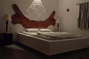 - un lit avec une grande tête de lit en bois dans une chambre dans l'établissement Zephyr - In The Sky, à Khamshet